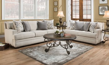 American-made fabric upholstered couch in an off-white, cream color with four throw pillows.