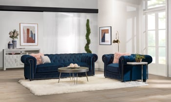 Midnight blue velvet chesterfield sofa with nailhead trim.