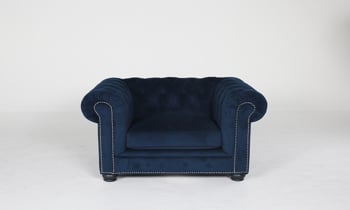 Midnight blue velvet chesterfield accent chair with nailhead trim.