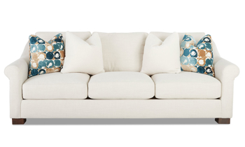 Klaussner handmade sofa in a neutral cream fabric that has 4 throw pillows.